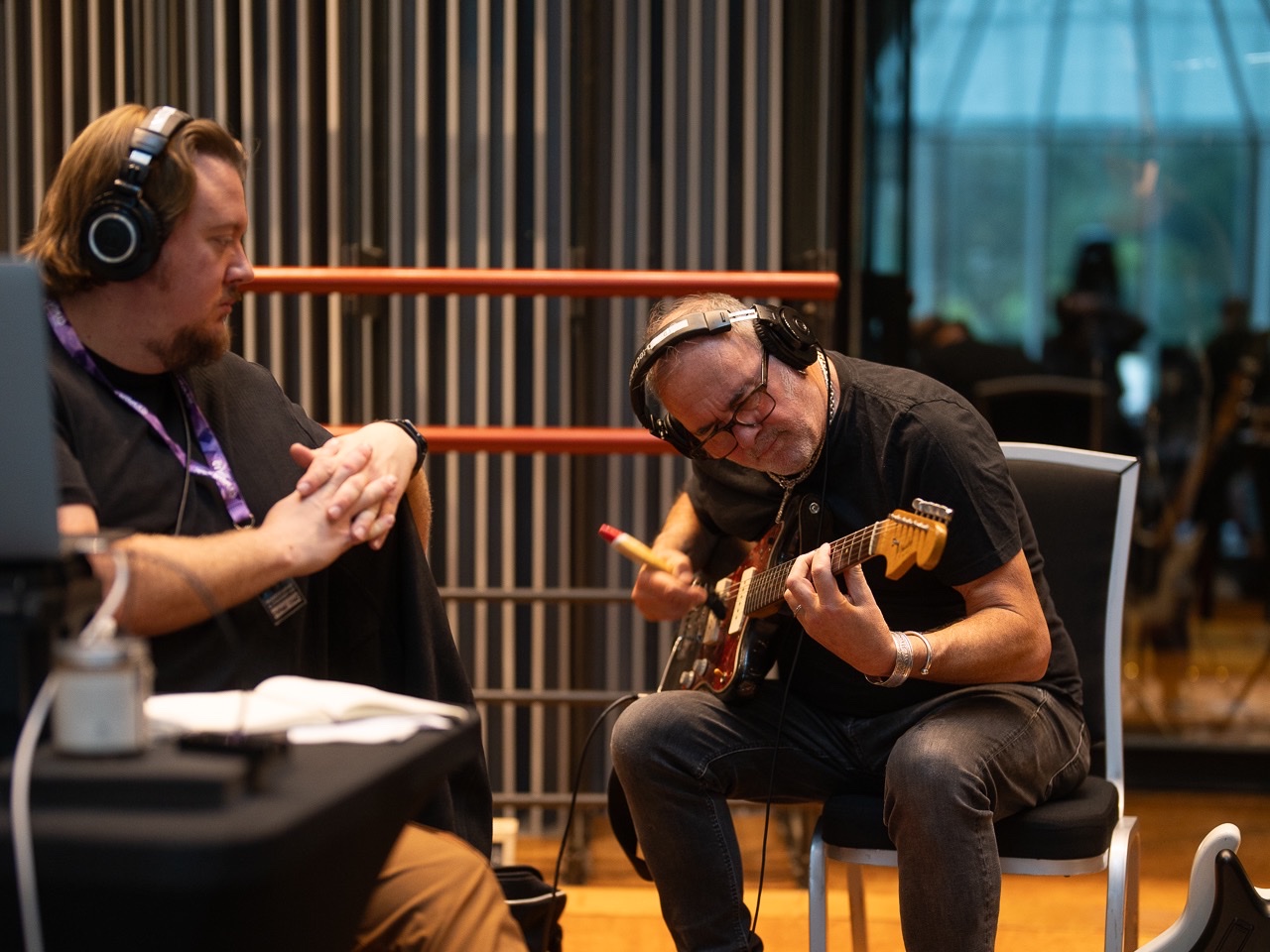 Musicians working through a guitar part in the studio