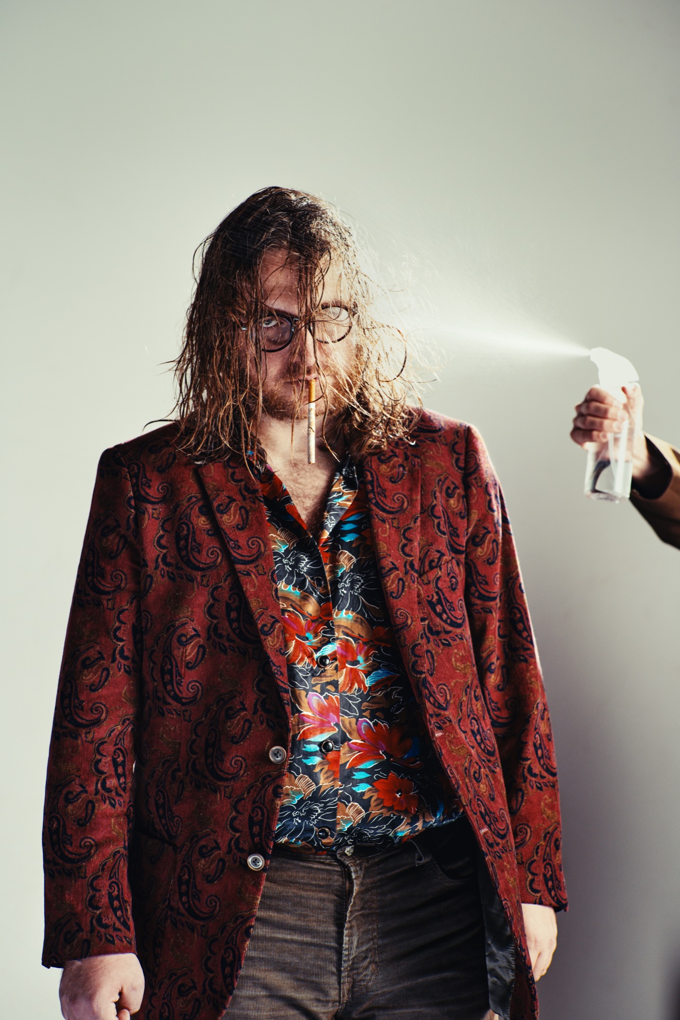 The Denim Emperor standing for a portrait while being sprayed with water