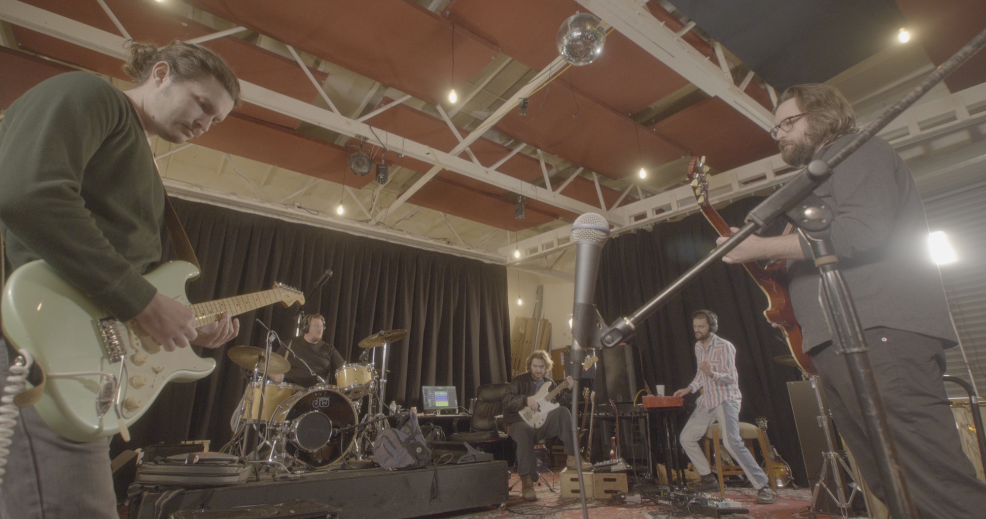 The Taverna Project performing together around a central studio microphone